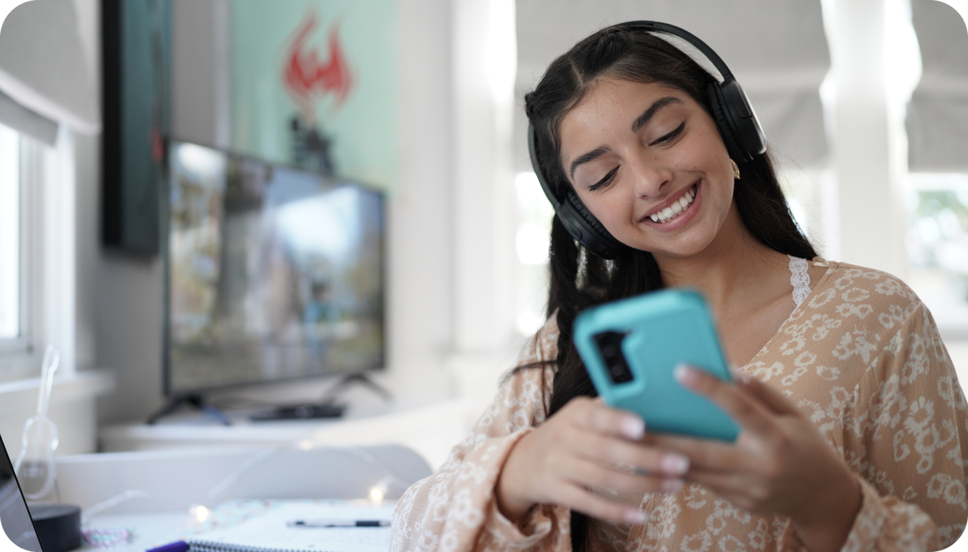Girl with headphones on, using her phone