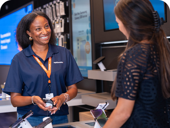 An Optimum Store sales representative helps a customer explore phone options.