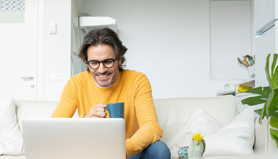 A man works from home on his laptop, using the speed and reliability of Optimum Internet in.